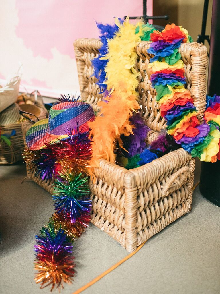 Rainbow-hued hats and boas in wicker box
