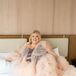 Bride in a Pink, Tulle Robe Lounging While Getting Ready for Her Wedding