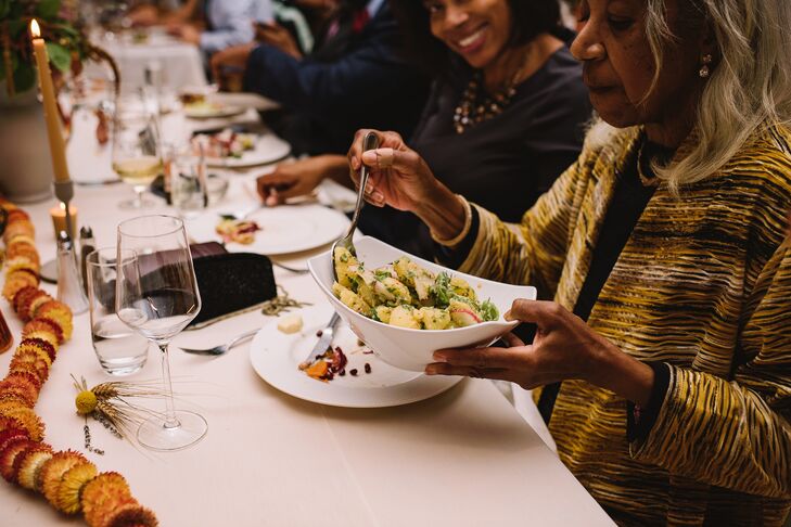 Guests Enjoying a Seated Dinner at Table With String of Dried Flowers