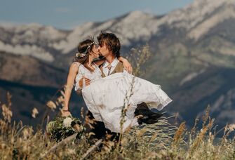 wedding couple kissing with montana mountain backdrop