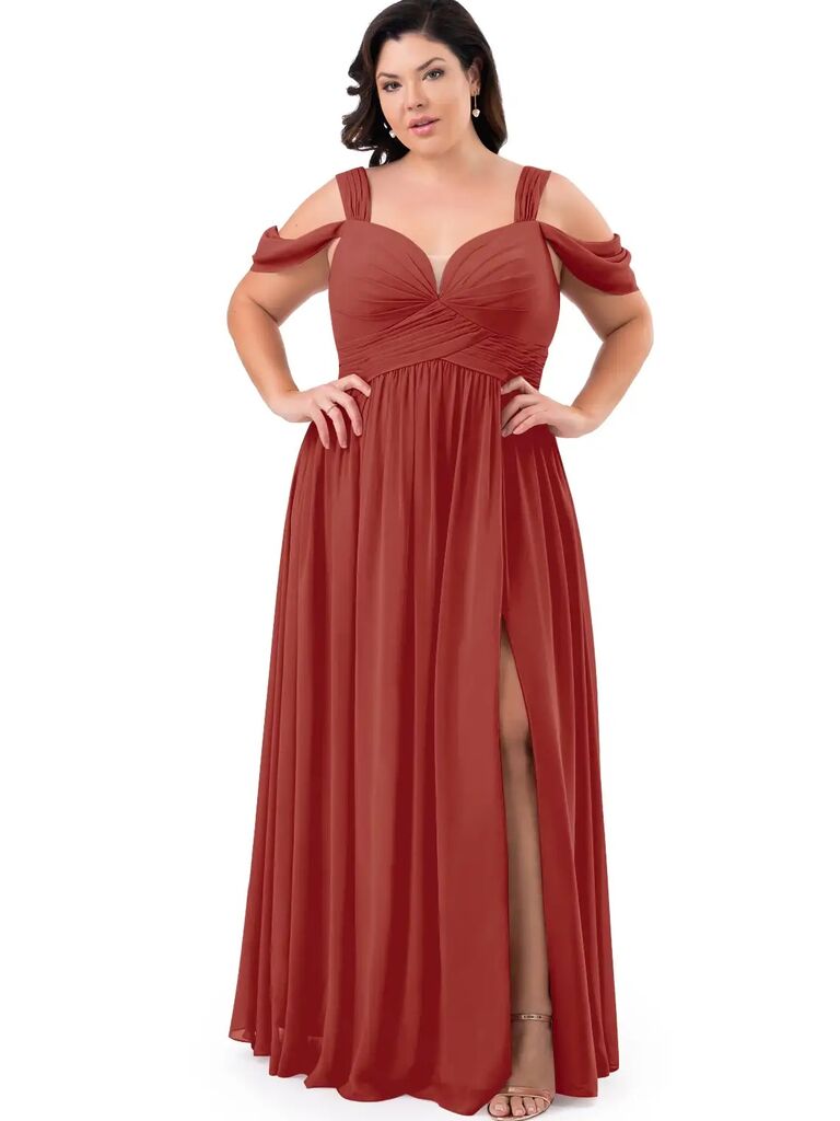 Model wears a burnt orange gown with beautiful Grecian sleeves. 