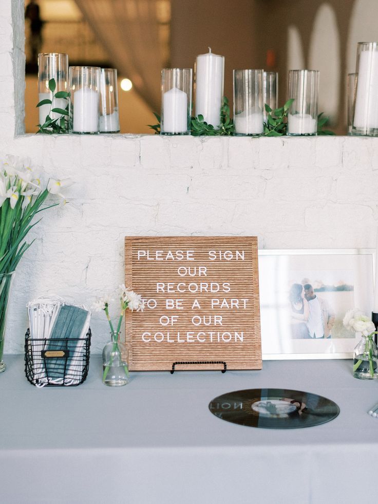 Vinyl record sitting on table beside letter board sign. 