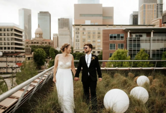 Bride and Groom Take a Stroll Through the Grass at Sunset Coffee Building wedding venue in Houston, Texas