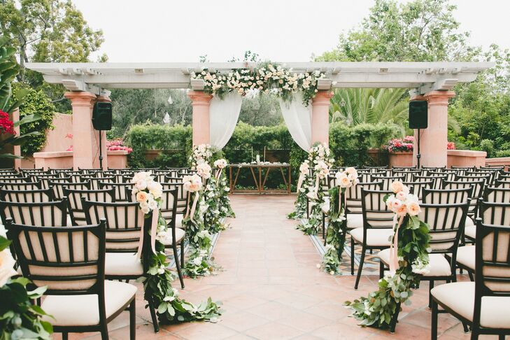 Greenery and peach and white blossoms decorated the aisle and the pergola that Carly and Kevin said their vows under.