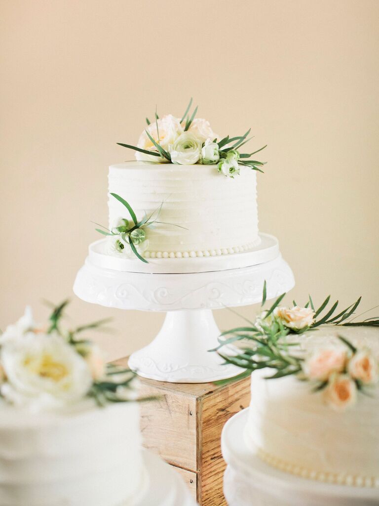 classic one tier wedding cake with white buttercream and white flowers