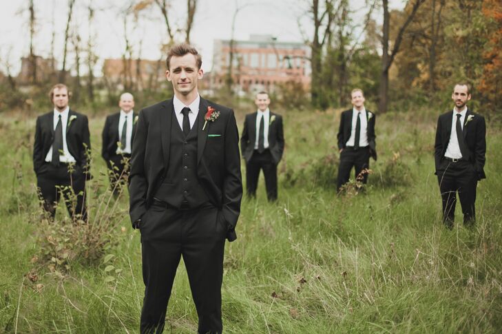 The groomsmen wore black suits with black ties. "It was an easy option since most of them already had suits," the bride says. "Johnathan wore the same, but added a black vest and a green pocket square."