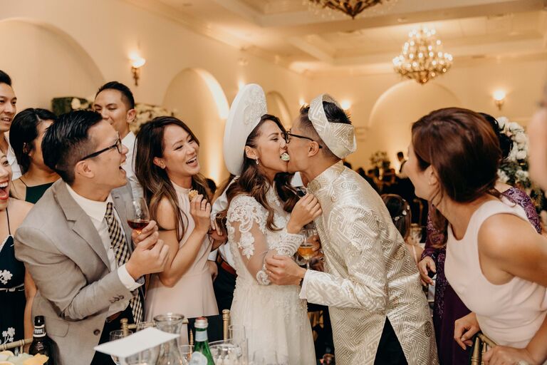 Couple eating food together during Vietnamese wedding reception