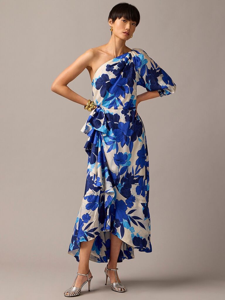 Model wearing a white asymmetrical dress with blue florals