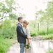 The bottom of Megan's ivory wedding dress train bundled behind her as she faced Carson. She wore a classic gown that blended in with the environment's natural colors.