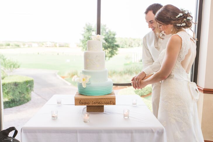Sofelle Confections made sure their wedding cake drew on Cami’s original vintage inspiration. Piped floral details resembled embroidery on the top tiers, while a cool ombre ruffled detail covered the remaining layers. Two sugar flowers with yellow and blue watercolor edges also accented the confection.