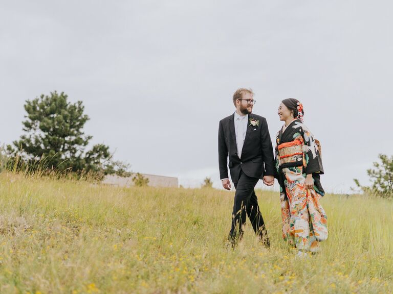 Couple holding hands in field