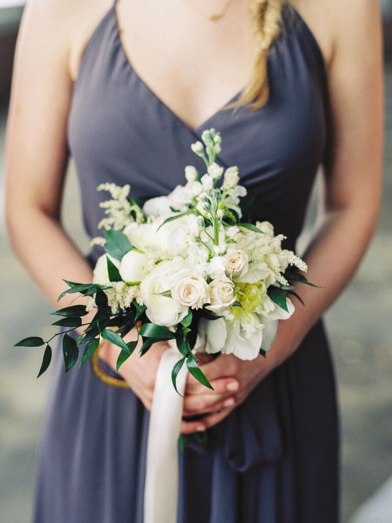 A bridesmaid holds this lovely pale bouquet.
