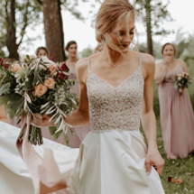 bride in Ashley wedding dress standing in front of bridesmaids