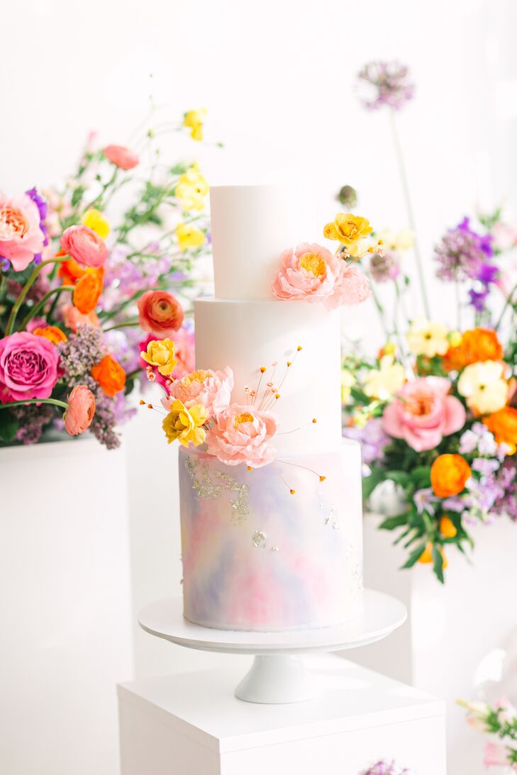 Wafer-paper flowers and gold leaf decorated the three-tier white chocolate and raspberry cake.