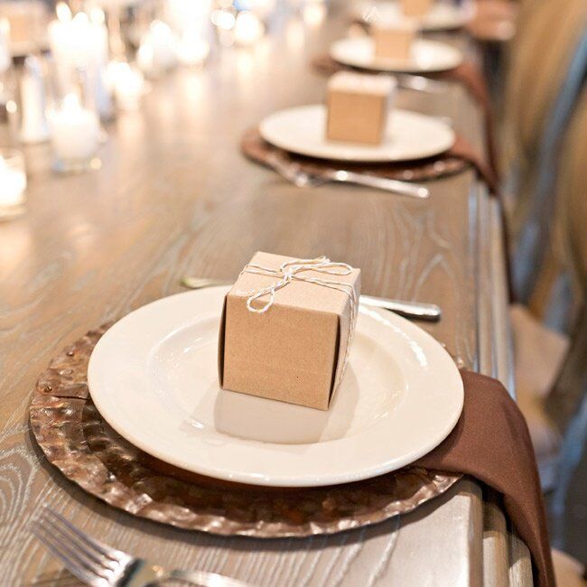 Kraft favor boxes were placed on brown place settings at each of the tables.