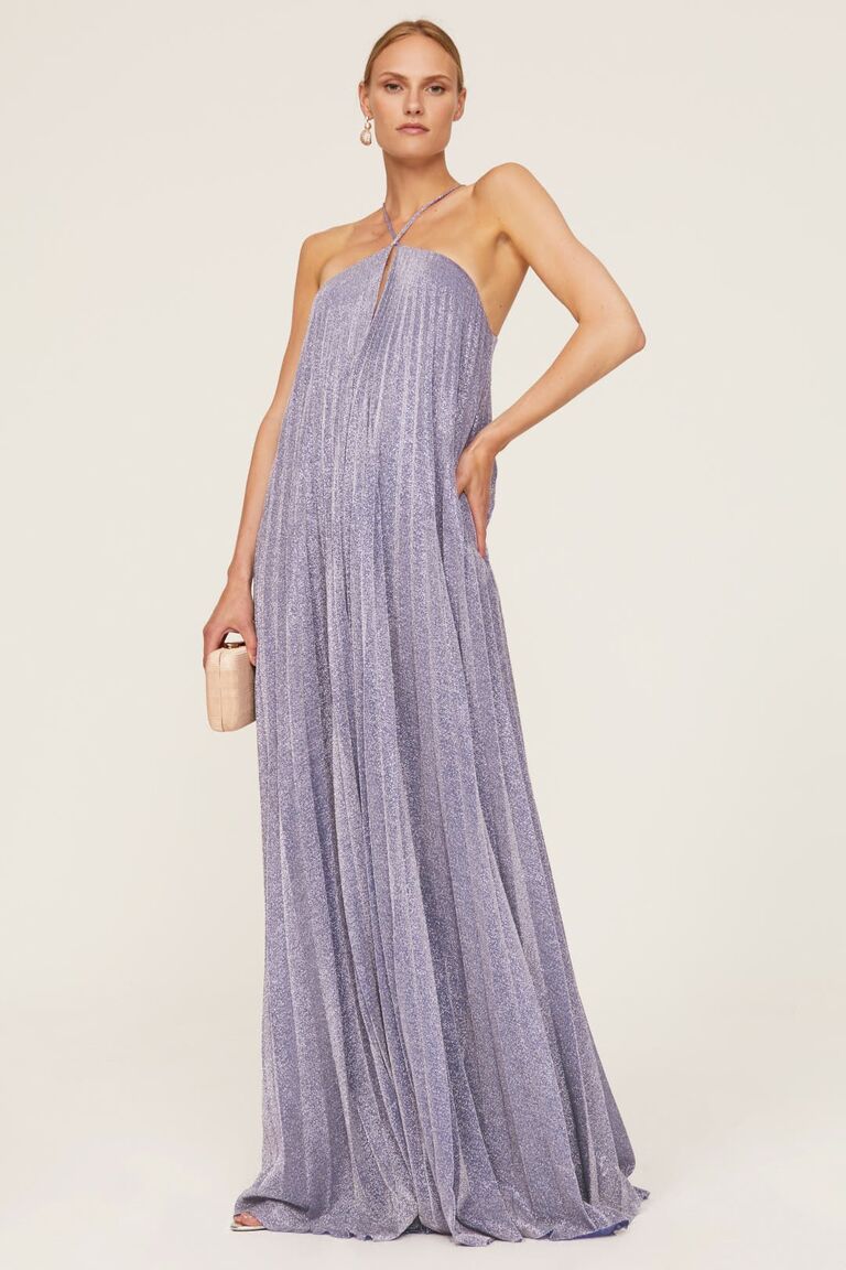 Model wears a halter-neck pleated purple gown. 