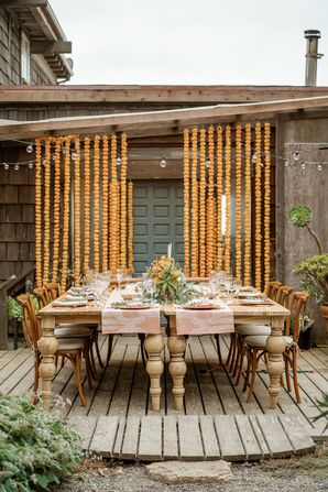 Backyard Wedding Reception With Wood Table and Marigold Garlands