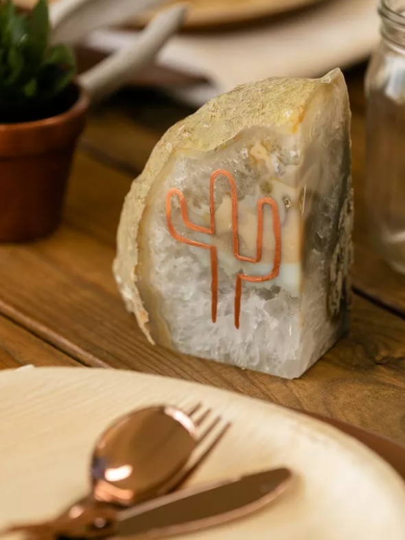 Rustic geode centerpiece with a bronze cactus outlined on the side. 