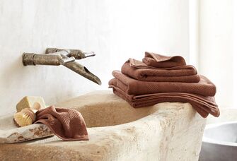 Set of colorful bath sheets and towels on bathroom sink