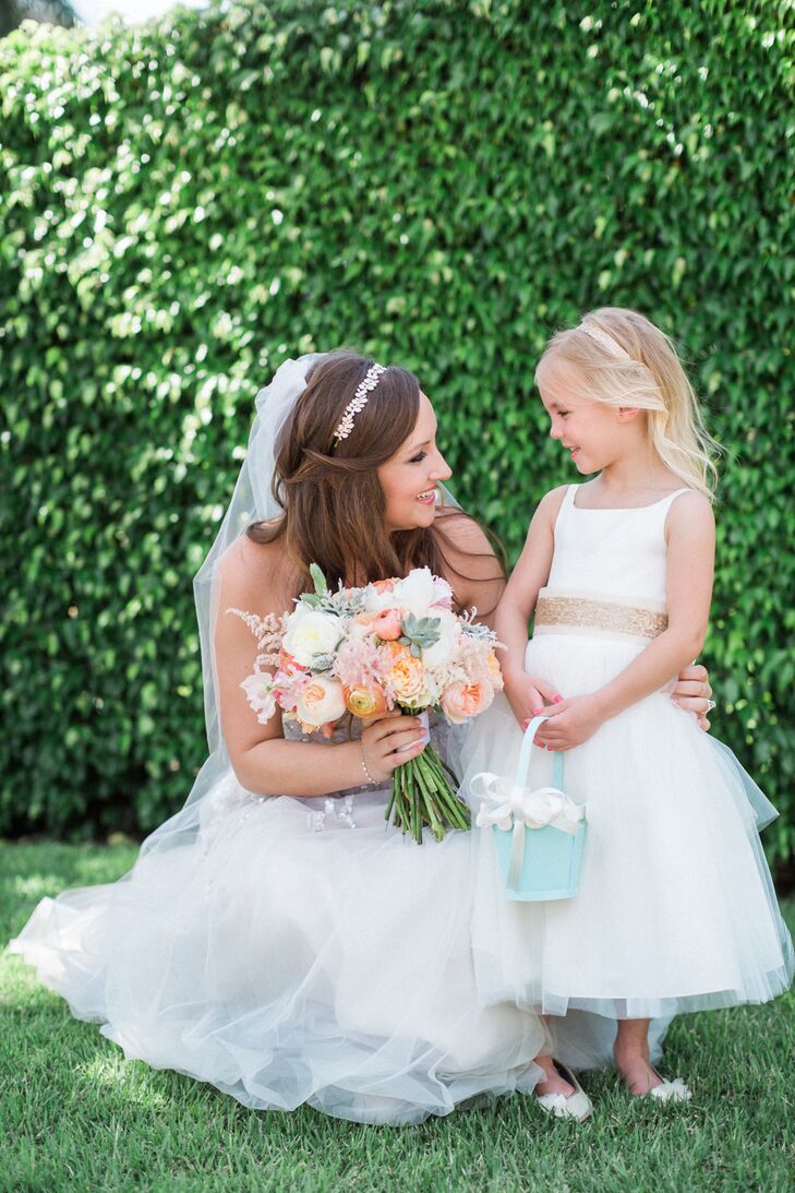 Instead of wearing mint to match the bridesmaids, the flower girl was ready to celebrate in a sweet ivory dress with a tulle overlay along the skirt. To stand out even more, Stephanie's cousin also wore a custom gold belt and a matching headband.