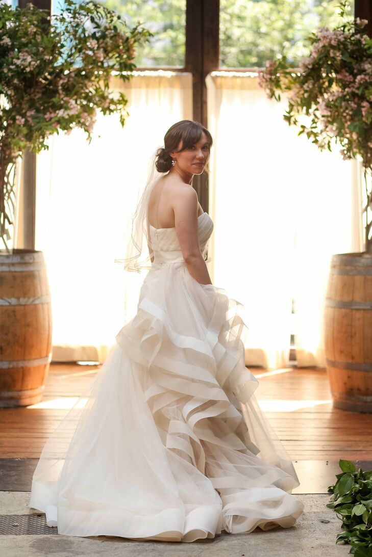 It didn’t take long for Emma to find the perfect gown for her “I do’s.” The bride-to-be was instantly drawn to a White by Vera Wang design at David’s Bridal with its dramatic organza ruffles and soft draped detailing. To let the gorgeous gown take center stage, she completed the look with a simple elbow-length veil and her mother’s pearl earrings.