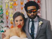 Couple posing with wedding photo booth props