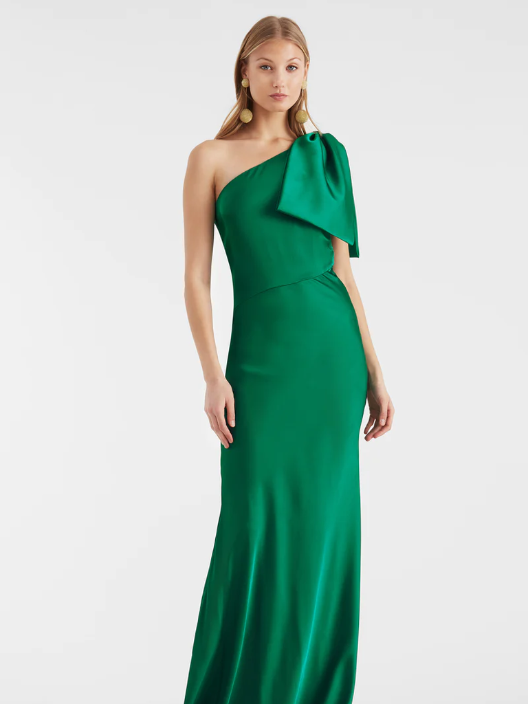 A model shows off this one-shoulder emerald green gown with a stylish bow.
