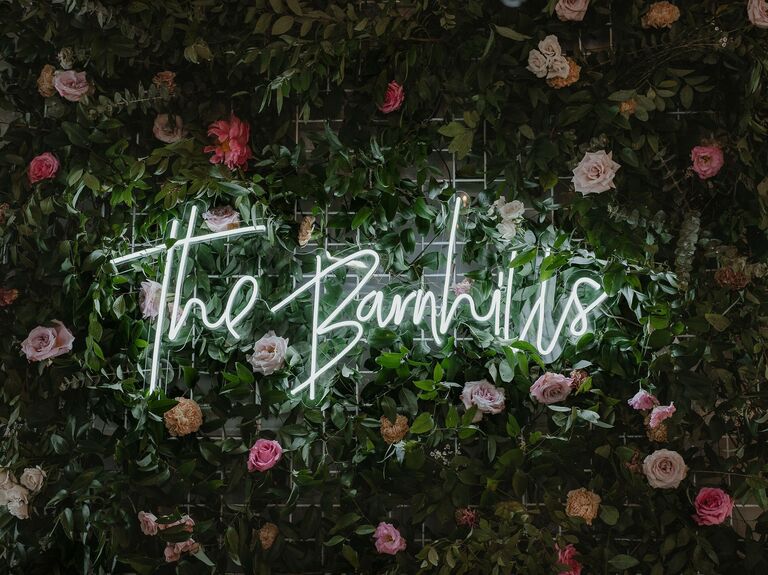 Neon sign on a rose wedding flower wall.