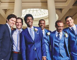 Groom and groomsmen in different colored blue suits