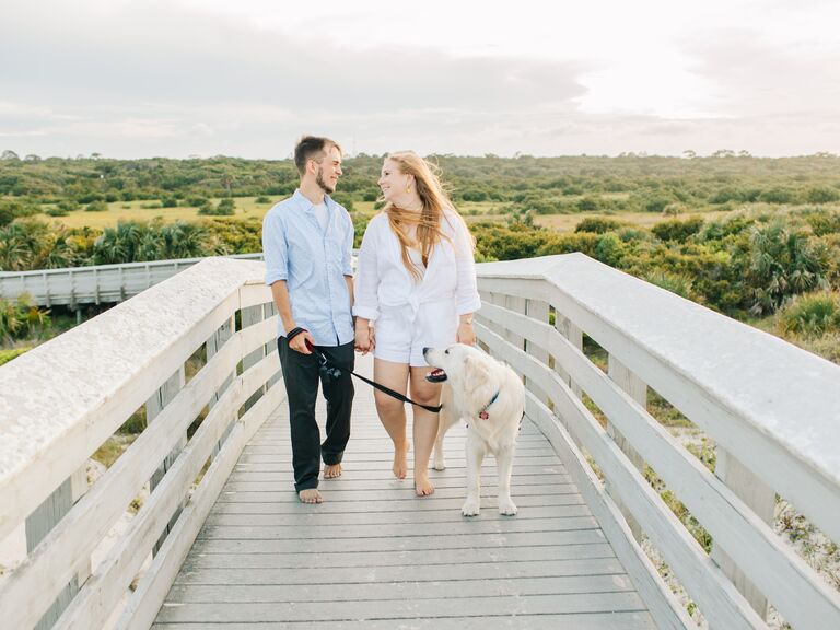 Sweet couple walking barefoot with their dog.