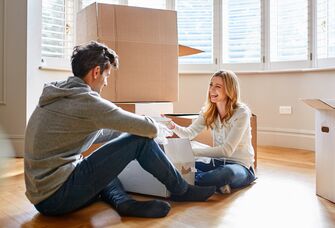 couple sitting on floor unpacking boxes together