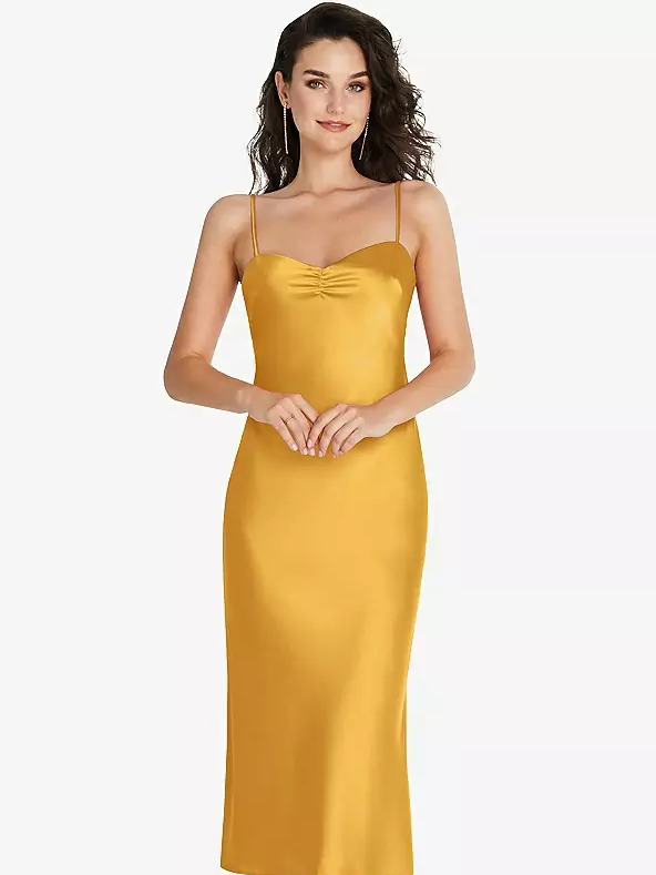 A model shows off a yellow spaghetti strap gown with a calf-length hem.
