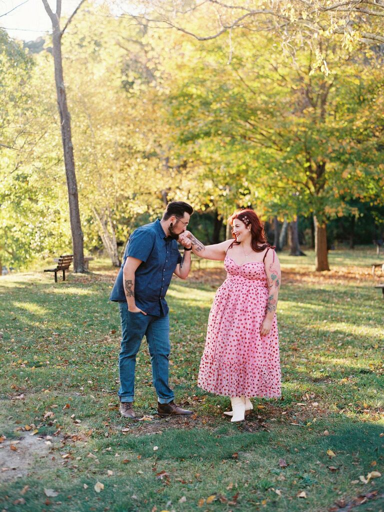 Man kisses his wife's hand while looking into her eyes. 