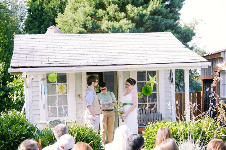 Melissa and Carl got married in front of the shabby-chic cottage that was located on her aunt and uncle's private property. The windows of the shack were decorated with green and white paper decorations, along with hanging chimes.