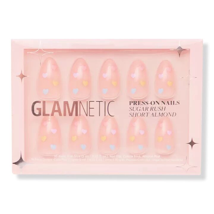 Pink almond-shaped press on nails with pastel colored hearts. 