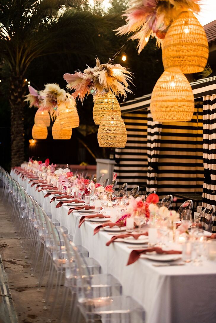 Long Reception Table Under Rattan Lights With Pampas Grass and Pink Accents