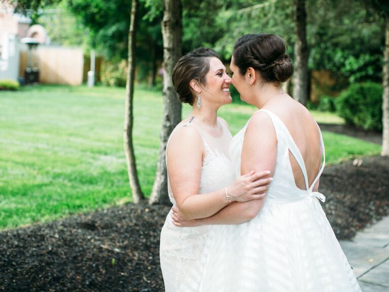 Brides smiling at each other hugging