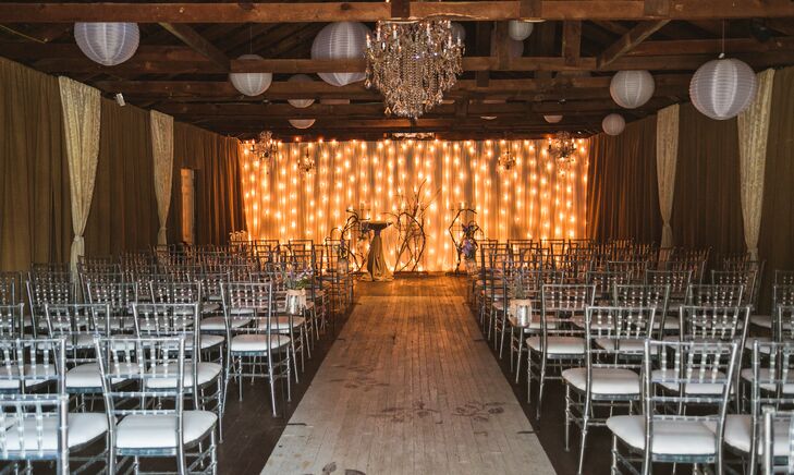 Marianne and John had their ceremony in the barn-style chapel at the Kyle House. They hung white paper lanterns from exposed wood beams around the crystal chandelier and set up silver chiavari chairs with a center aisle. The ceremony backdrop was a curtain of string lights.