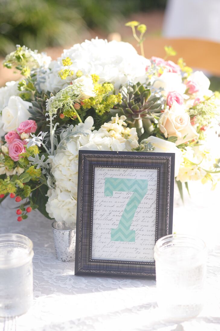 The couple decorated each round reception table with a chevron table number and lush floral centerpiece. Each arrangement included white hydrangea, blush roses, pink tea roses, succulents and dusty miller.