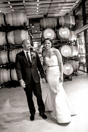 Couple Posing with Barrels of Wine at Winery Wedding