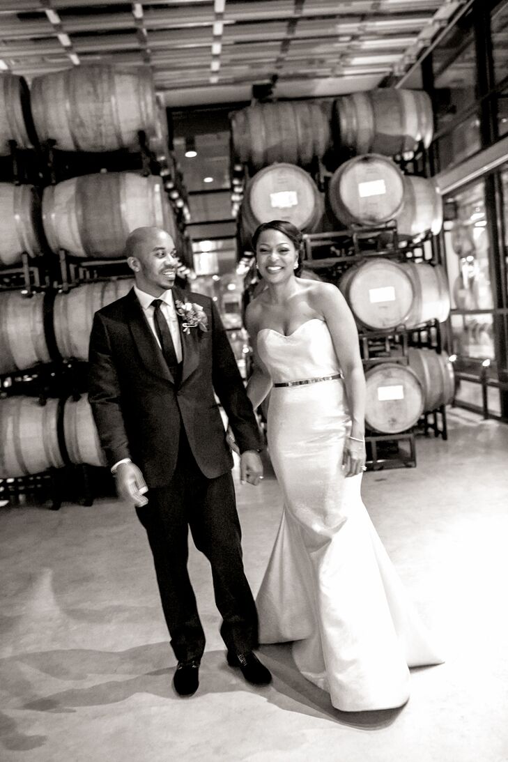 Couple Posing with Barrels of Wine at Winery Wedding