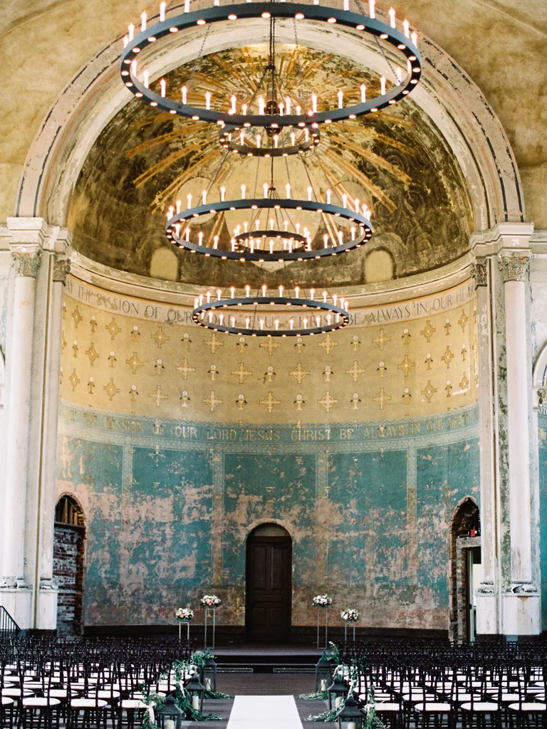 A gorgeous antique chandelier hangs within this religious celebration space.