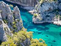 best honeymoon destinations a beautiful photo of gordes south of france with massive rocks and teal blue water plus kayaks