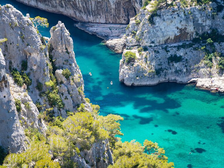 best honeymoon destinations a beautiful photo of gordes south of france with massive rocks and teal blue water plus kayaks