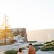 Bride Wiping Tear Away From Groom in Pale Burnt Orange Suit