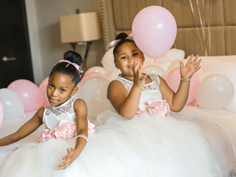 Flower girls wear their hair in sleek top knots. 