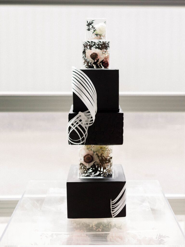 modern square wedding cake with black fondant, flowers in clear acrylic tier separators and white sugar swirls