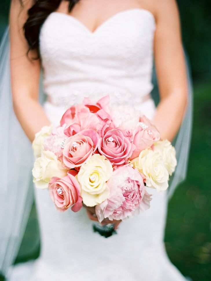 For the ceremony at the Boston Public Garden, Lei Lei carried a classic bouquet of roses and peonies in shades of ivory and pink down the aisle. To play up the shimmery details of her gown, while adding a touch of glam factor to her bridal look, Amy Wedding Decoration incorporated rhinestone gems throughout the arrangement.