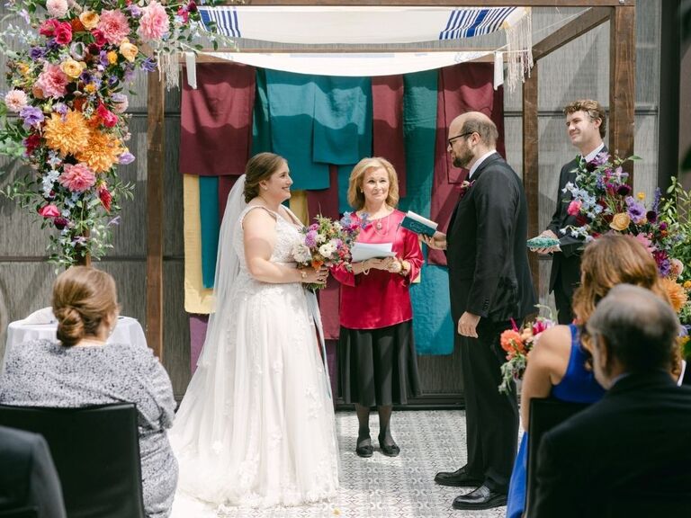 Couple exchanging Jewish wedding vows under chuppah