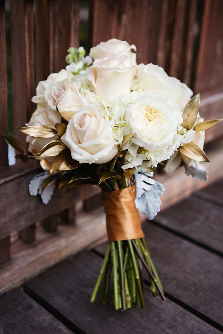 Christine carried white roses, hydrangeas, garden roses and dusty miller accents with spray painted gold leaves to match the ivory, blush and gold color palette.